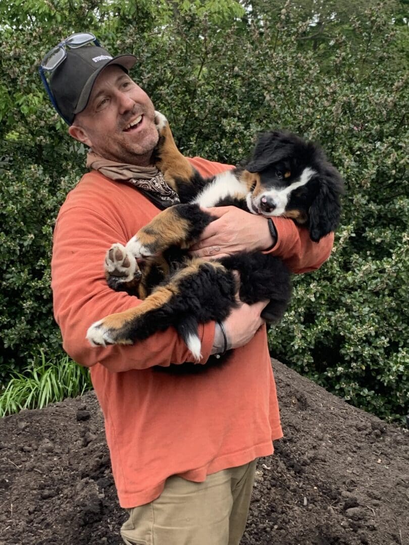 A man holding a dog in his arms.